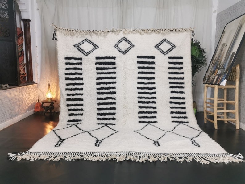 Handmade Moroccan White Black Wool Rug 9.84 x 6.56 Feet: Handmade Moroccan White Black Wool Rug 9.84 x 6.56 Feet Enhance your living space with this stunning handmade white wool rug, featuring striking black lines and shapes. Crafted by skilled Berber women