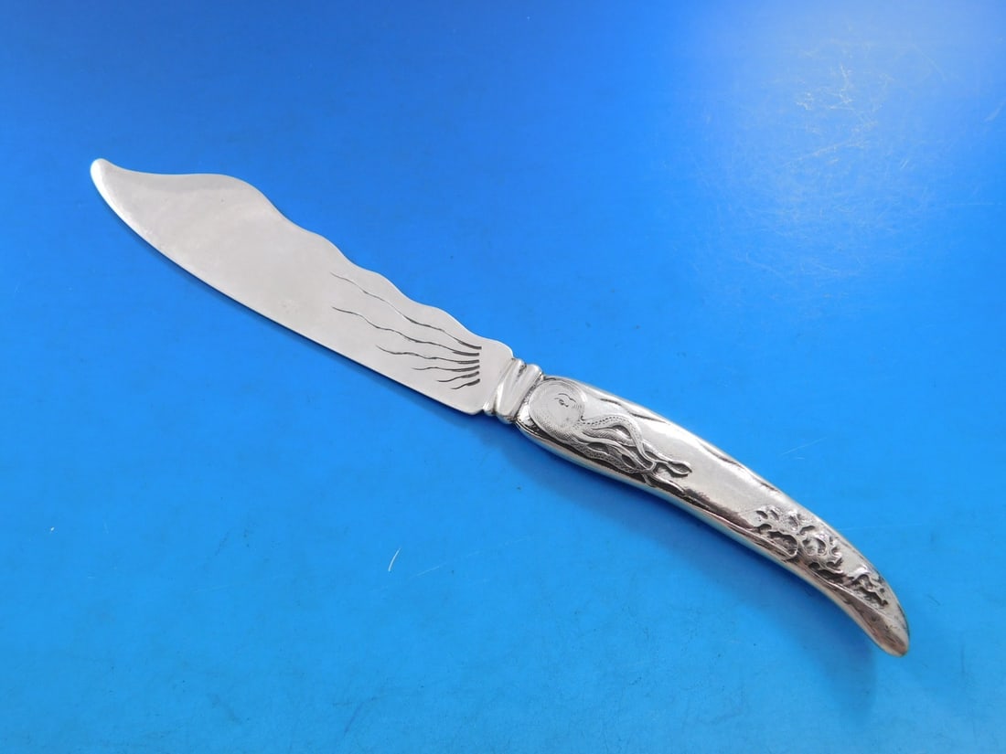 Tiffany Sterling Silver Fish Knife Lap Over Edge Octopus 7 5/8": Tiffany Sterling Silver Fish Knife Lap Over Edge Octopus 7 5/8" This exquisite fish knife, crafted by Tiffany & Co. in the Lap Over Edge pattern, showcases a stunning acid-etched design featuring an u