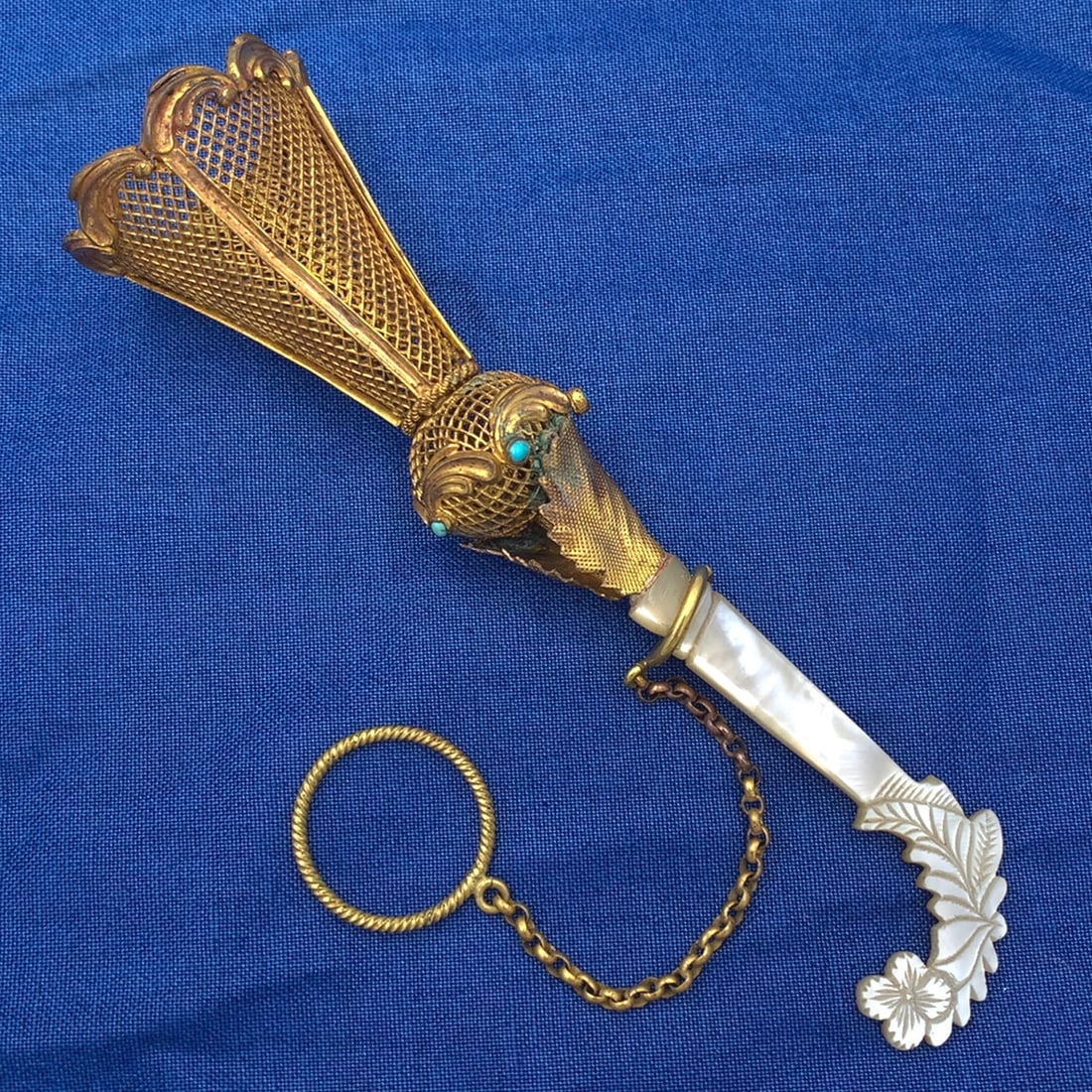 Victorian Gilt Tussie Mussie with Turquoise and Mother of Pearl Handle: Victorian Gilt Tussie Mussie with Turquoise and Mother of Pearl Handle This exquisite gilt tussie mussie features a decorative mesh cup and a beautifully carved mother of pearl shell handle, adorned w
