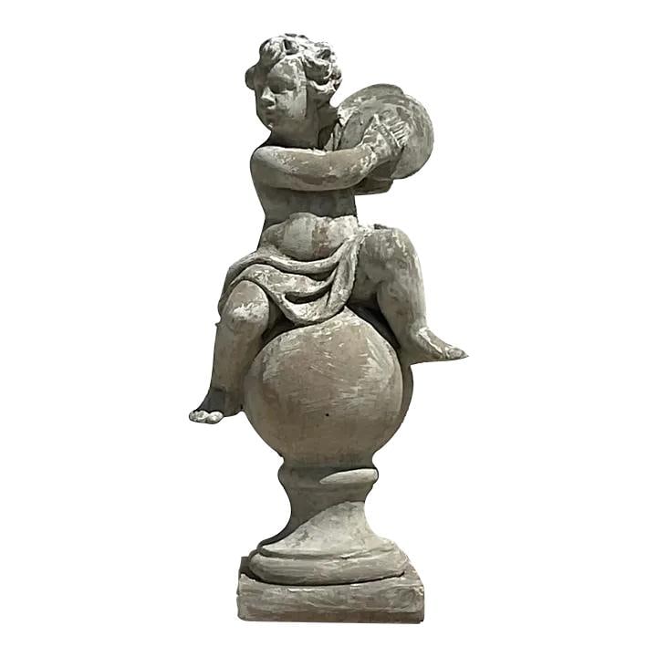 Vintage Regency Cherub Concrete Sculpture 37.75" Tall: Vintage Regency Cherub Concrete Sculpture 37.75" Tall This vintage Regency cast concrete figural sculpture features a whimsical cherub seated atop a round pedestal. With its aged patina and classical