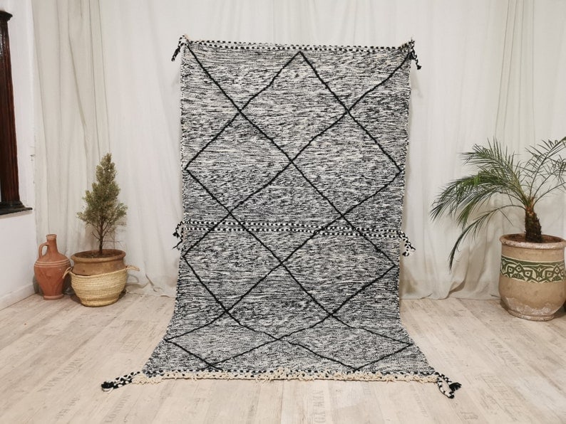 Authentic Grey Handmade Moroccan Berber Wool Rug 6.56 x 3.28 Feet: Authentic Grey Handmade Moroccan Berber Wool Rug 6.56 x 3.28 Feet Experience the warmth and artistry of this authentic Grey Handmade Moroccan Berber Wool Rug, featuring a striking black geometric patt