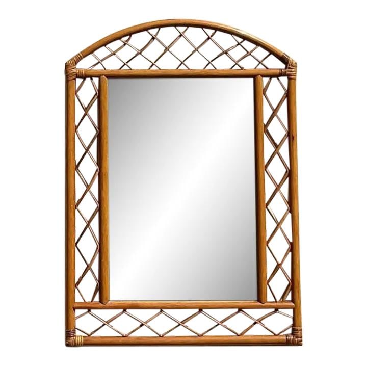 Vintage Coastal Arched Rattan Wall Mirror Palm Beach Estate: Vintage Coastal Arched Rattan Wall Mirror Palm Beach Estate This stunning vintage coastal wall mirror features a chic arched shape accentuated by a decorative trellis design. The mirror was acquired f