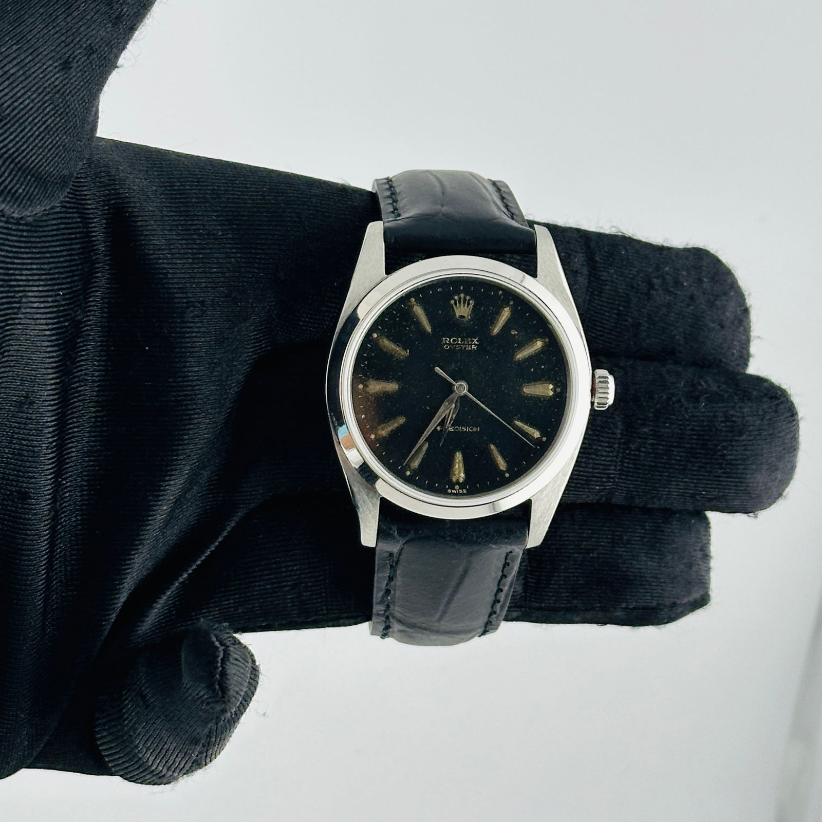 Oyster Precision 6424 Watch with Black Dial and Aftermarket Leather Strap: Oyster Precision 6424 Watch with Black Dial and Aftermarket Leather Strap This Rolex Oyster Precision watch features a sleek black dial and a smooth bezel. It is paired with an aftermarket leather bra