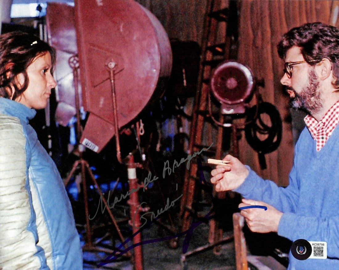 Star Wars 8x10 Signed Photo George Lucas Maria de Aragon Beckett LOA: Star Wars 8x10 Signed Photo George Lucas Maria de Aragon Beckett LOA This rare 8x10 inch color photograph captures a behind-the-scenes moment from the original Star Wars (A New Hope), featuring George