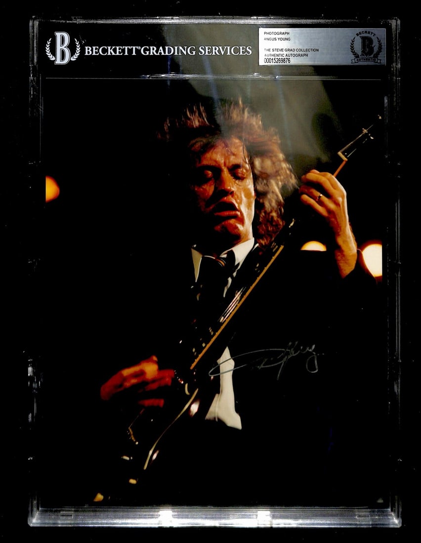 Angus Young AC/DC Signed 8x10 Photo with Beckett Authentication: Angus Young AC/DC Signed 8x10 Photo with Beckett Authentication This is an autographed 8X10 photograph of Angus Young from the iconic rock band AC/DC. The photograph features his signature in silver p