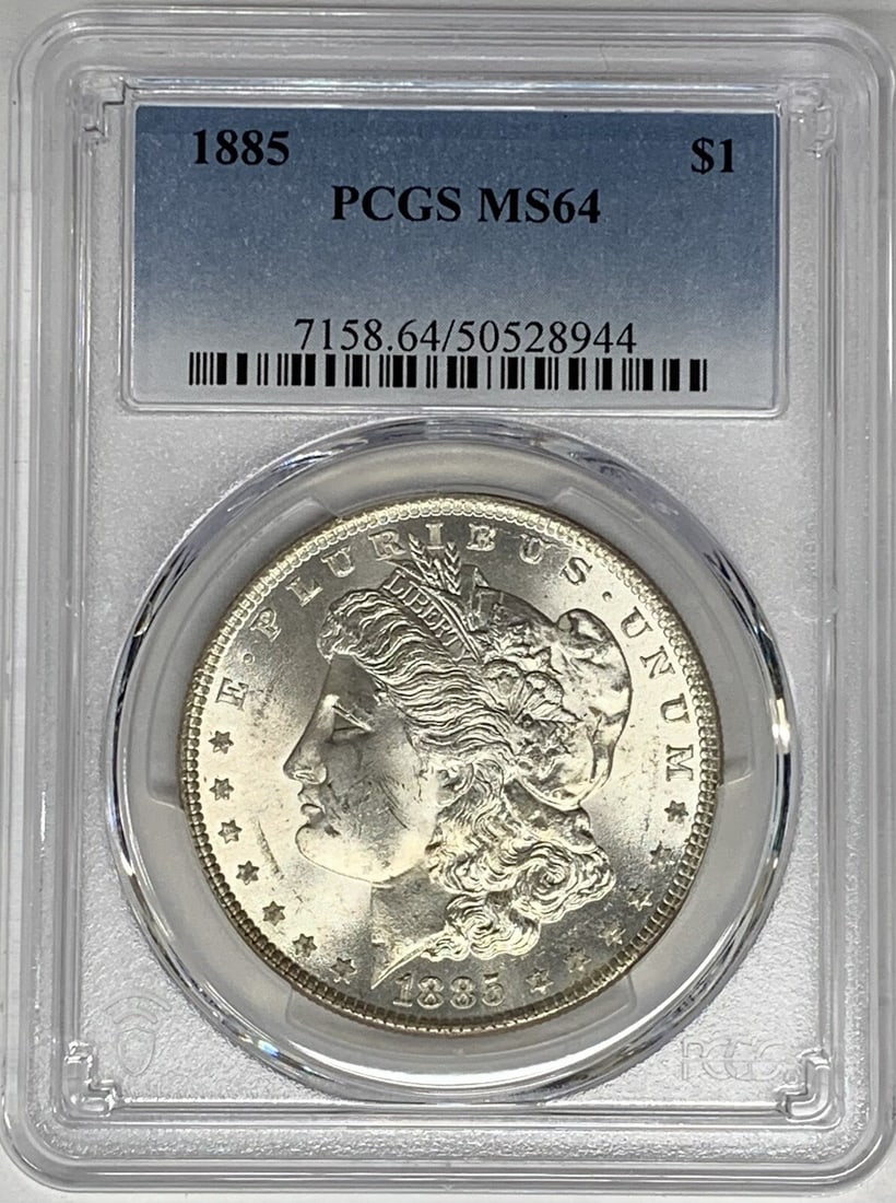 PCGS MS 64 1885 Silver Morgan Dollar Uncirculated US Coin: PCGS MS 64 1885 Silver Morgan Dollar Uncirculated US Coin This 1885 Morgan Silver Dollar is graded MS 64 by PCGS. The coin is uncirculated and features the classic Morgan design. It is composed of sil
