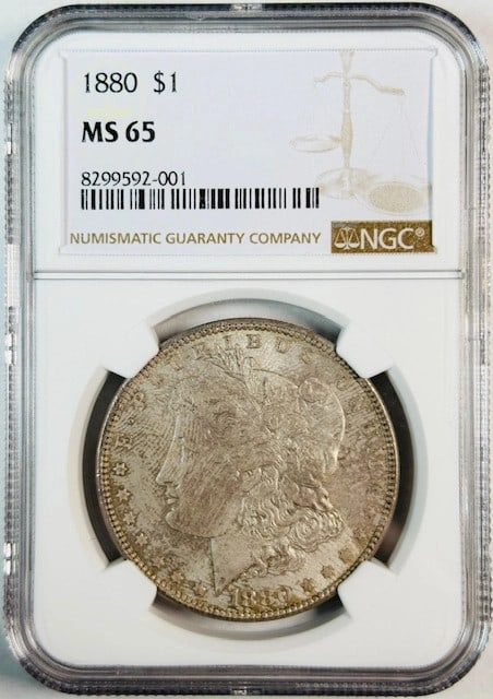NGC Graded 1880 MS 65 Morgan Silver Dollar Coin: NGC Graded 1880 MS 65 Morgan Silver Dollar Coin This 1880 Morgan Silver Dollar is graded MS 65 and certified by NGC. Struck in silver, it is an uncirculated coin from the United States, making it a de