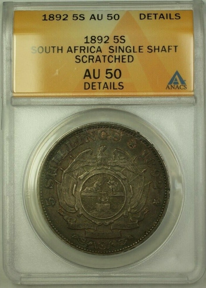 ANACS AU 50 Graded 1892 South Africa 5 Shillings Silver Coin Single Shaft: ANACS AU 50 Graded 1892 South Africa 5 Shillings Silver Coin Single Shaft This 1892 South Africa 5 Shillings coin is composed of 0.925 fine silver and has been certified by ANACS with an AU 50 grade.