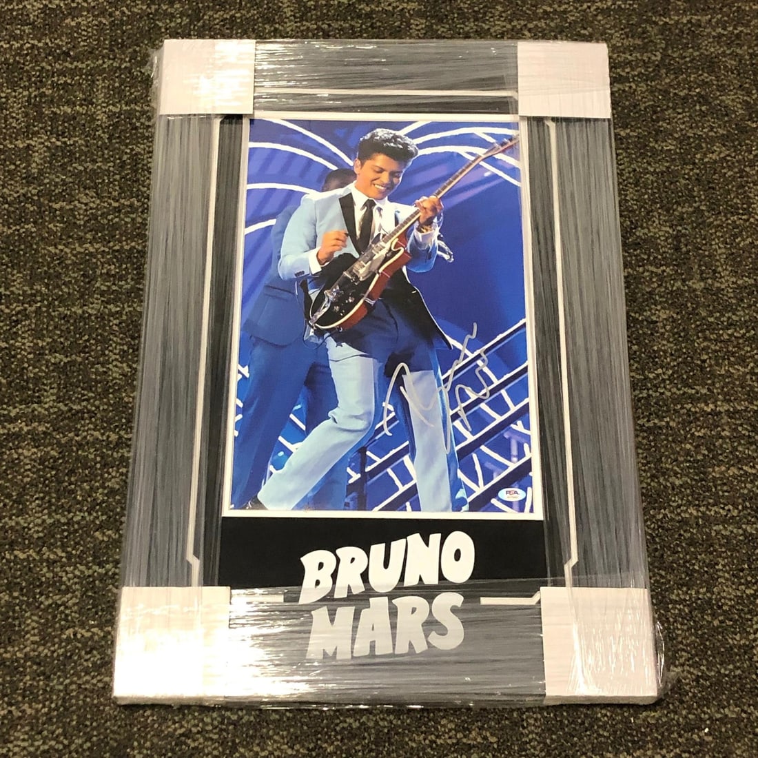 Bruno Mars Framed Autographed Photo PSA/DNA 21x26 Original: Bruno Mars Framed Autographed Photo PSA/DNA 21x26 Original Enhance your collection with this professionally framed photo of Bruno Mars, featuring his authentic autograph. This stunning piece measures