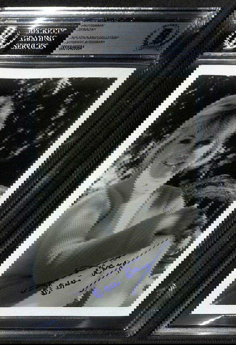 Doris Day Signed 5x7 Photo BECKETT Authentic Hollywood Icon: Doris Day Signed 5x7 Photo BECKETT Authentic Hollywood Icon This exquisite 5x7 black and white photograph features the legendary actress and singer Doris Day, personally signed in bold blue ink. The s