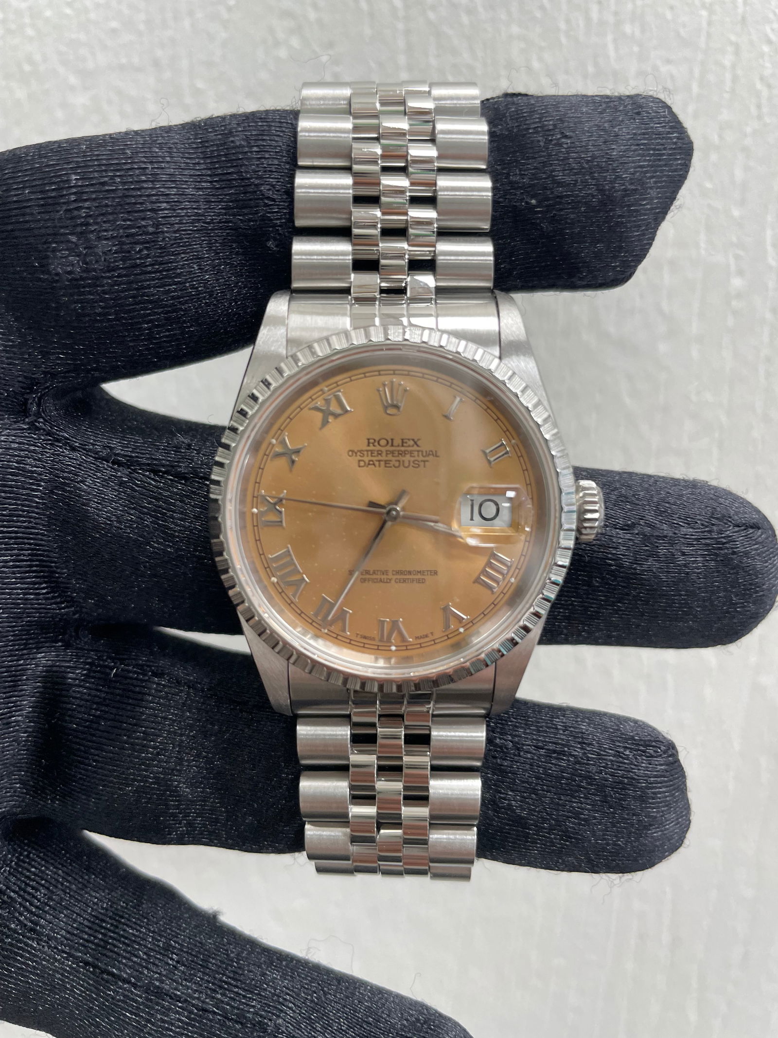 Datejust 16220 Men's Watch Copper Dial Jubilee Bracelet: Datejust 16220 Men's Watch Copper Dial Jubilee Bracelet This Rolex Datejust features a copper dial and is paired with a Jubilee bracelet. The watch includes an engine-turned bezel and is designed for