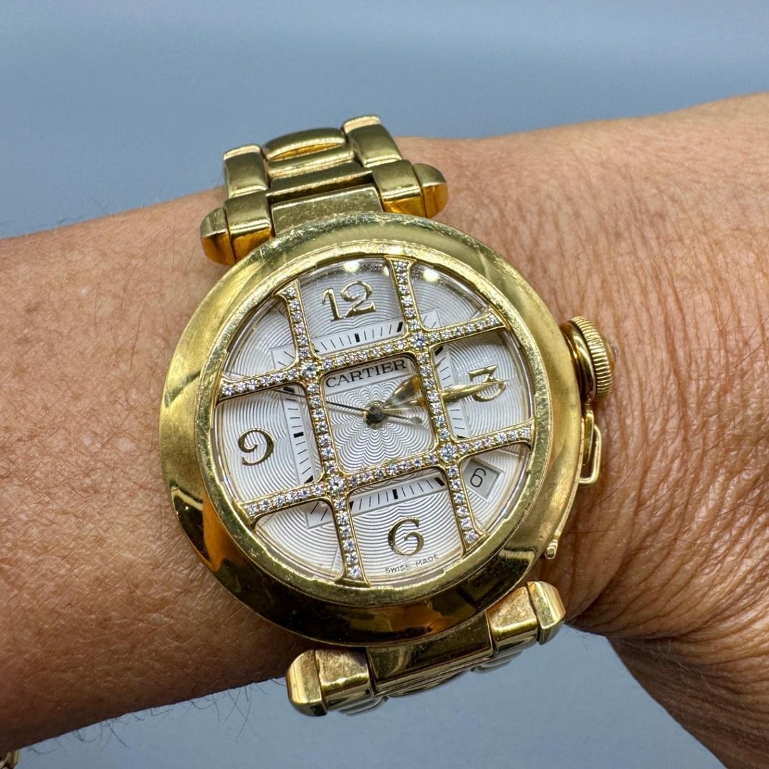Pasha Watch in 18K Yellow Gold with Diamond Grill 35mm Automatic: Pasha Watch in 18K Yellow Gold with Diamond Grill 35mm Automatic This is a Cartier Pasha watch crafted from 18K yellow gold, featuring an original diamond grill design. The watch has a 35mm case and a