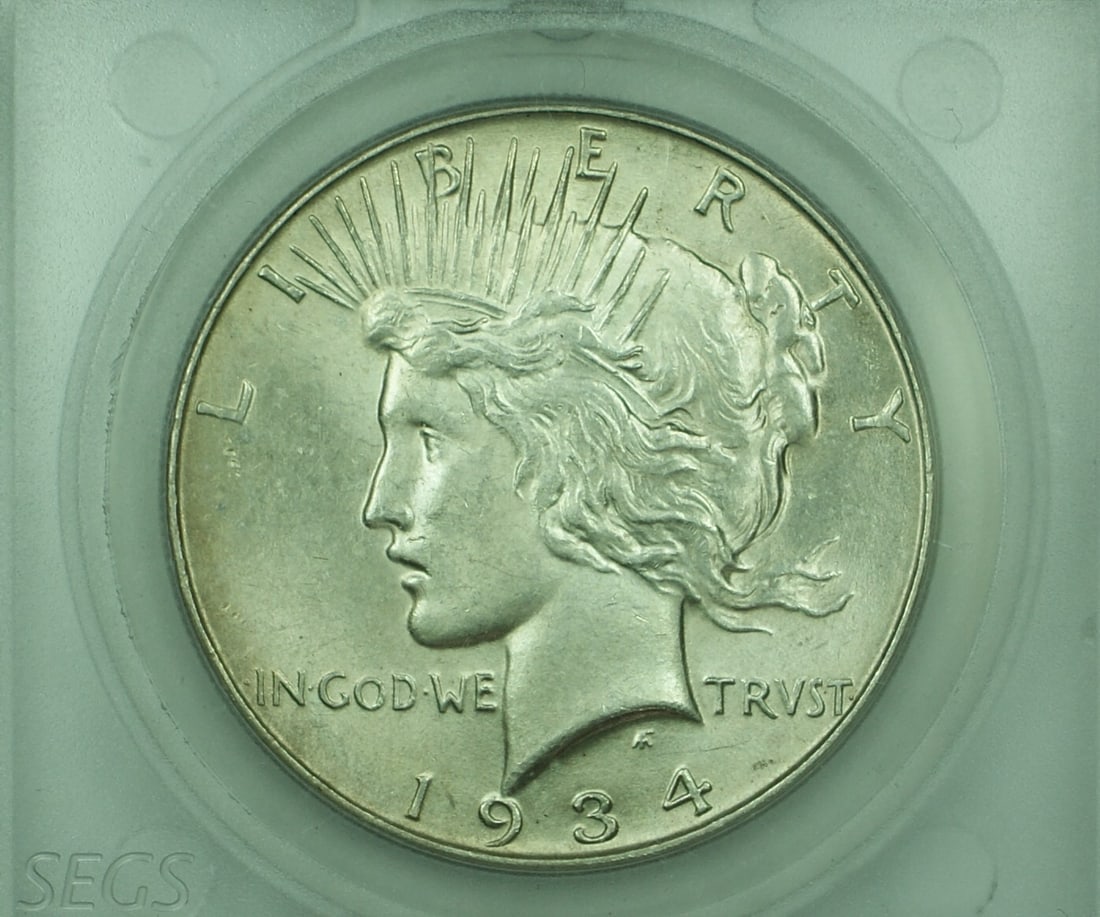 1934 Peace Silver Dollar Uncirculated Toned in Plastic Holder: 1934 Peace Silver Dollar Uncirculated Toned in Plastic Holder This is a 1934 Peace Silver Dollar from the United States, featuring a toned appearance and housed in a hard plastic holder. The coin is u