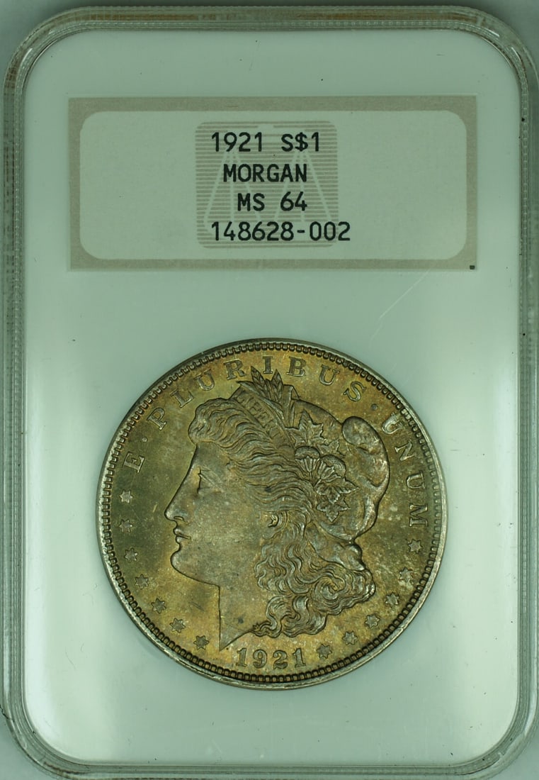 1921 Morgan Dollar NGC MS 64 Toned in Fatty Old Green Holder: 1921 Morgan Dollar NGC MS 64 Toned in Fatty Old Green Holder This 1921 Morgan Silver Dollar features attractive toning and is graded MS 64 by NGC, housed in a classic NGC Fatty OGH holder. The coin is