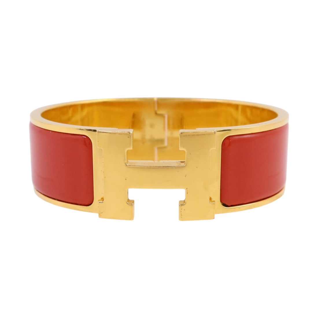 Red Enamel Hermes Clic-Clac H Bracelet with Gold Tone Hardware: Red Enamel Hermes Clic-Clac H Bracelet with Gold Tone Hardware This Hermes Clic-Clac H bracelet features a bold red enamel design with metal accents. Crafted in France, it offers a stylish and recogni