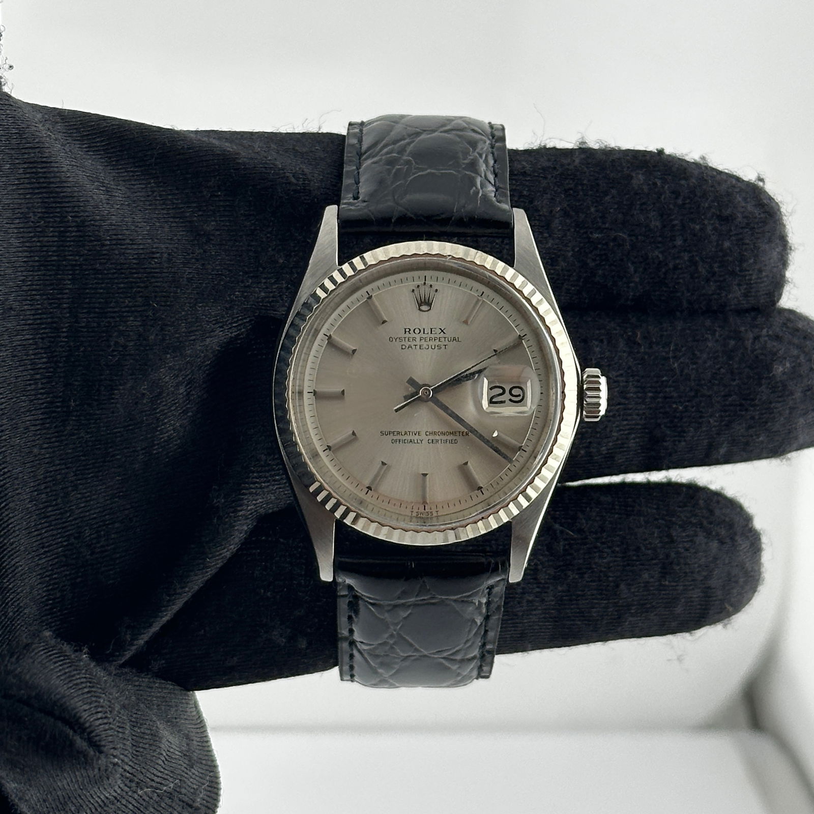 Rolex Datejust Ref 1601 Silver Stick Dial Aftermarket Leather Bracelet: Rolex Datejust Ref 1601 Silver Stick Dial Aftermarket Leather Bracelet This Rolex Datejust features a silver stick dial and a fluted bezel, paired with an aftermarket leather bracelet. The watch is de