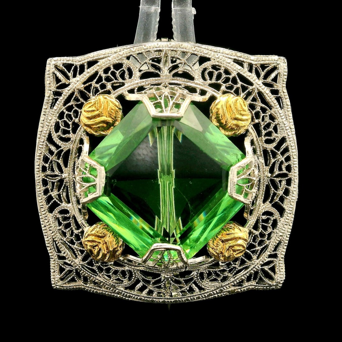 Antique Art Deco 10k White Gold Filigree Green Stone Brooch: Antique Art Deco 10k White Gold Filigree Green Stone Brooch This exquisite Antique Art Deco brooch pin features a lab-grown green stone set in a delicate filigree design. The rounded square shape of t