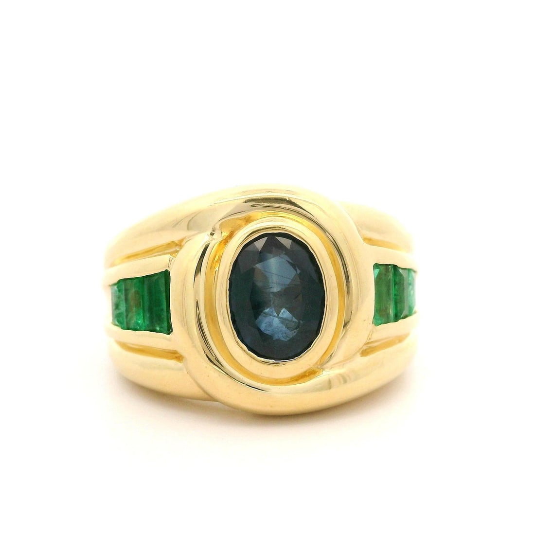 Elegant 18k Yellow Gold Oval Sapphire and Baguette Emerald Ring: Elegant 18k Yellow Gold Oval Sapphire and Baguette Emerald Ring This exquisite wide band ring features a stunning oval natural sapphire at its center, measuring approximately 7.5x5.5mm and weighing ar