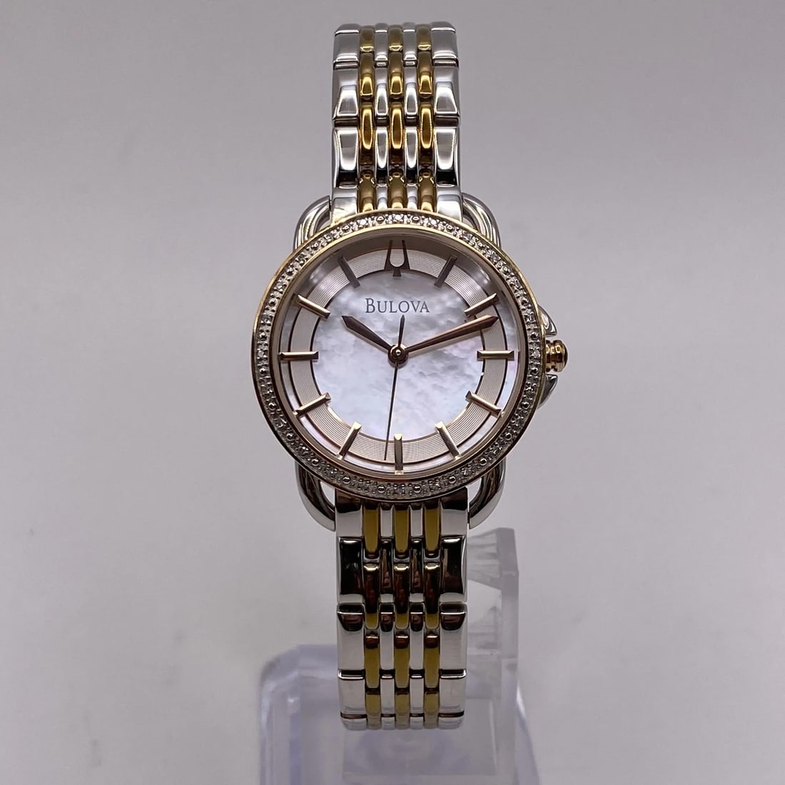 Bulova 98R144 Ladies Quartz Watch Two Tone Steel MOP Dial: Bulova 98R144 Ladies Quartz Watch Two Tone Steel MOP Dial This elegant Bulova ladies quartz watch features a stunning mother of pearl dial with 12-hour stick indexes, set within a polished round stain