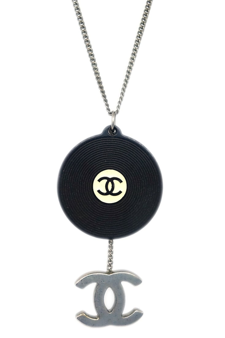 Chanel 04P Silver Plated Record Pendant Necklace: Chanel 04P Silver Plated Record Pendant Necklace This exquisite Chanel Record Silver Chain Pendant Necklace showcases a unique record-shaped pendant that adds a playful yet elegant touch to any outfit