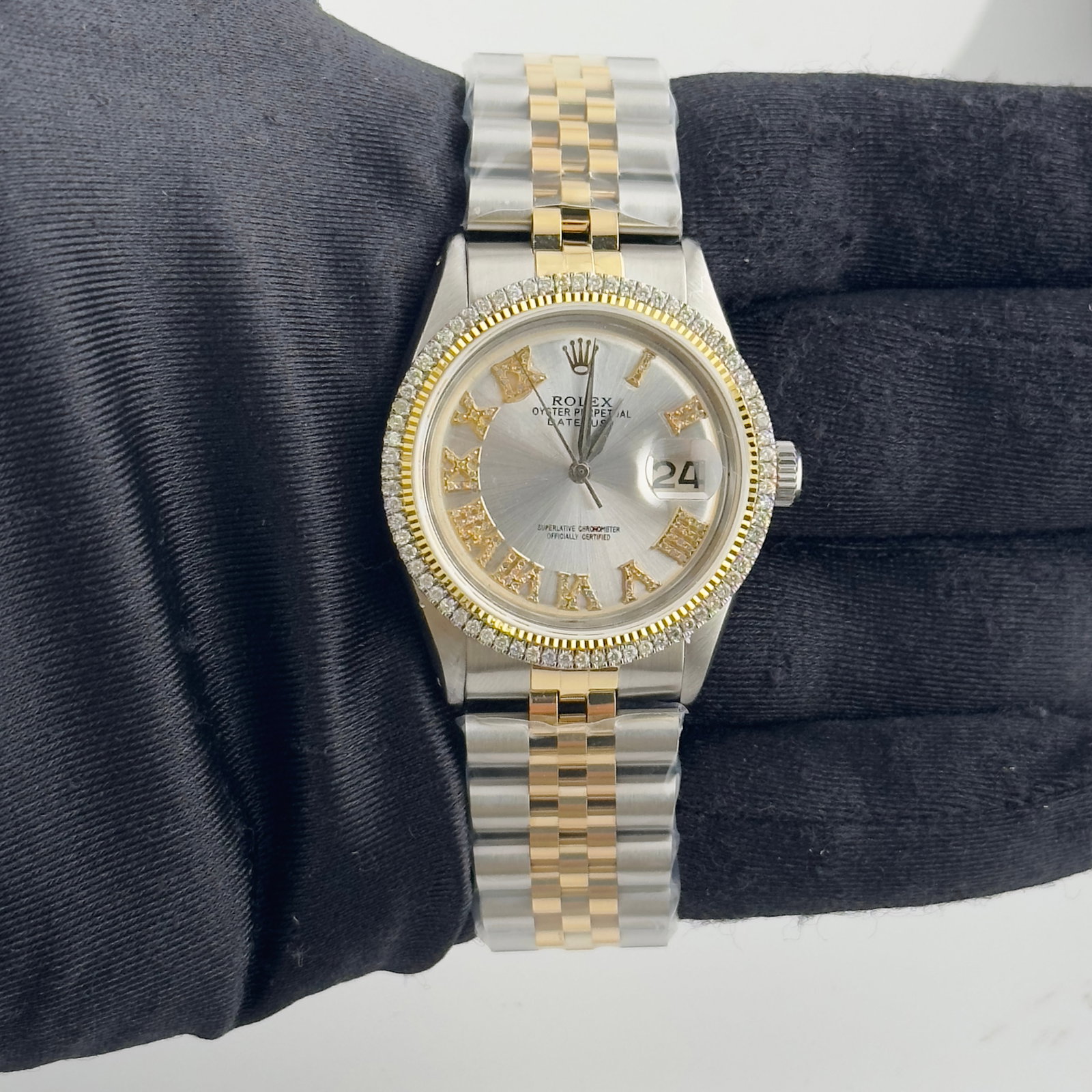 Aftermarket Silver Roman Diamond Dial Jubilee Rolex Datejust 1601: Aftermarket Silver Roman Diamond Dial Jubilee Rolex Datejust 1601 This Rolex Datejust watch features an aftermarket silver dial with Roman numerals and diamond accents. It is equipped with an aftermar