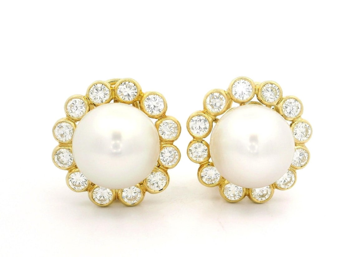 18k Yellow Gold 13.8mm Pearl Diamond Halo Earrings 3.6ctw: 18k Yellow Gold 13.8mm Pearl Diamond Halo Earrings 3.6ctw Elevate your elegance with these stunning 18k Yellow Gold earrings featuring natural button pearls and a dazzling diamond halo. Each earring s