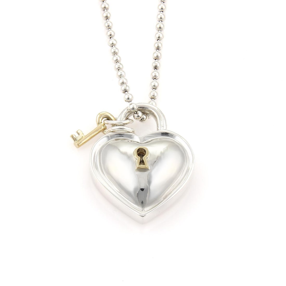 Tiffany & Co. Vintage Heart Padlock Key Pendant Necklace in Sterling Silver & 18k Gold: Tiffany & Co. Vintage Heart Padlock Key Pendant Necklace in Sterling Silver & 18k Gold This stunning vintage necklace from Tiffany & Co. is expertly crafted from sterling silver with luxurious 18k yel