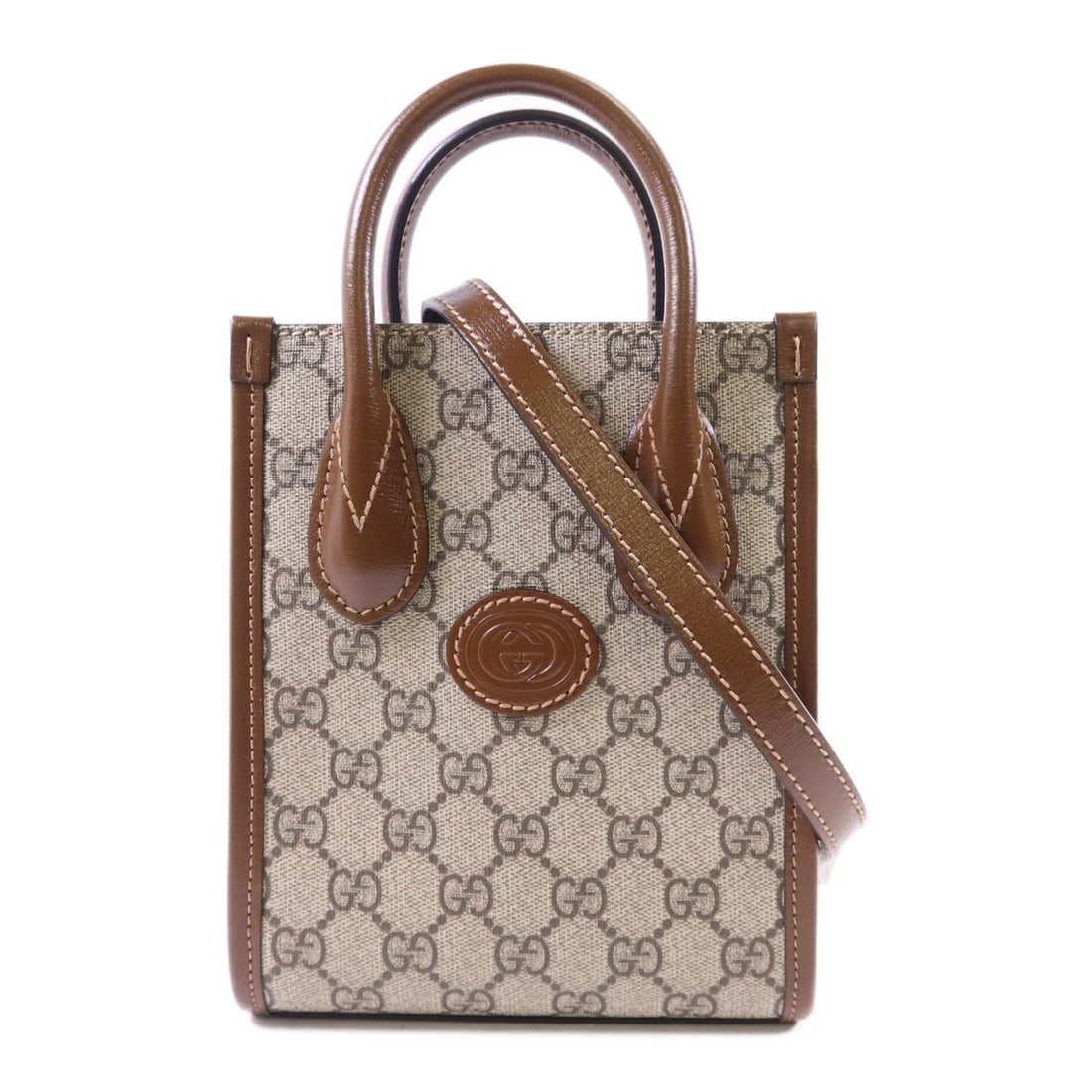 Brown Mini Tote 2 Way Shoulder Bag Gucci GG Interlocking PVC Canvas: Brown Mini Tote 2 Way Shoulder Bag Gucci GG Interlocking PVC Canvas This Gucci GG Interlocking G Mini Tote Bag offers versatile styling as a 2-way shoulder bag. Crafted in brown PVC coated canvas, it