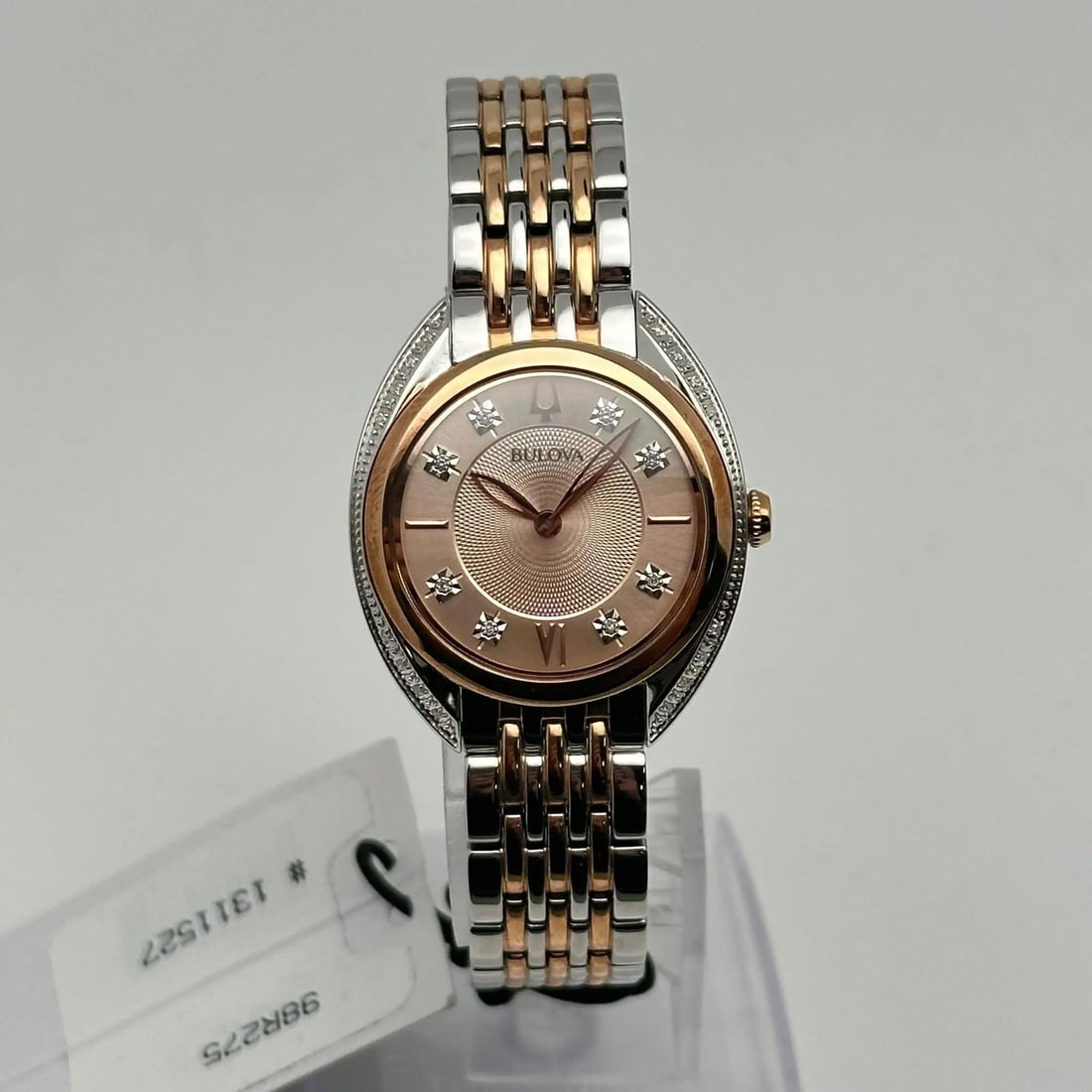 Bulova 98R275 Two-Tone Ladies Quartz Watch with Diamond Bezel: Bulova 98R275 Two-Tone Ladies Quartz Watch with Diamond Bezel This Bulova ladies quartz wristwatch features a stylish rose gold-tone dial complemented by a diamond-accented fixed bezel. The watch show