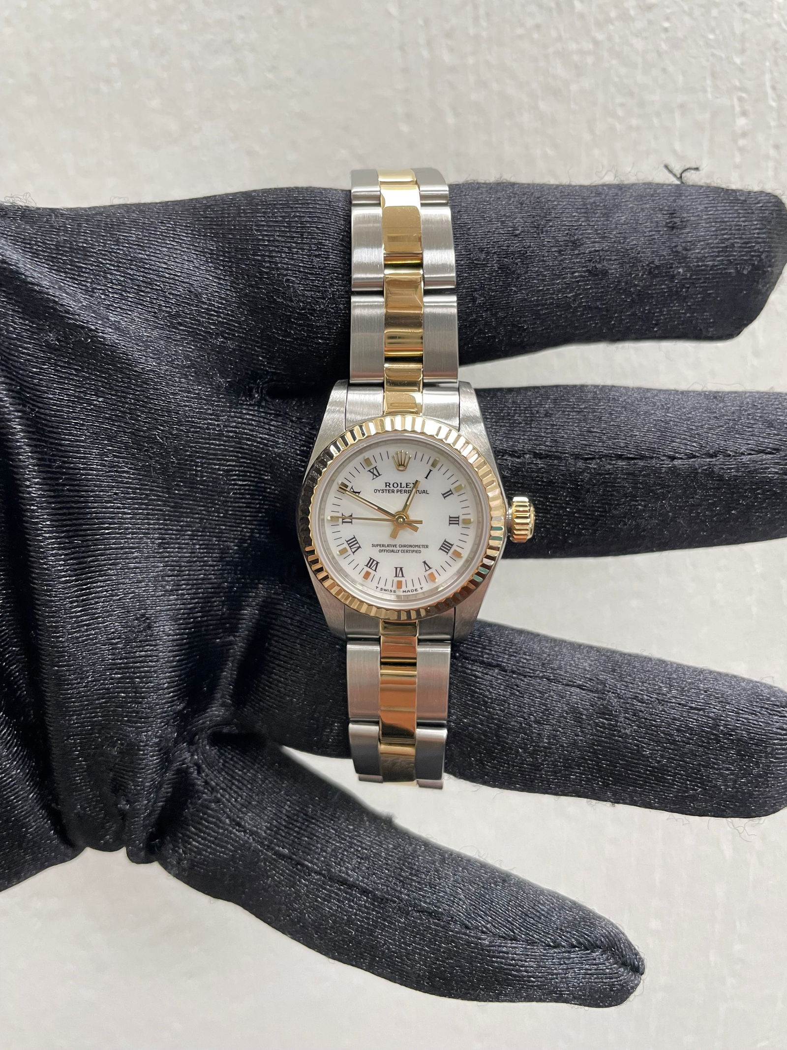 Ladies Rolex 67193 Oyster Perpetual White Roman Dial Watch with Papers 1997: Ladies Rolex 67193 Oyster Perpetual White Roman Dial Watch with Papers 1997 This Rolex Oyster Perpetual features a white Roman numeral dial and a fluted bezel, paired with an Oyster bracelet. It is a