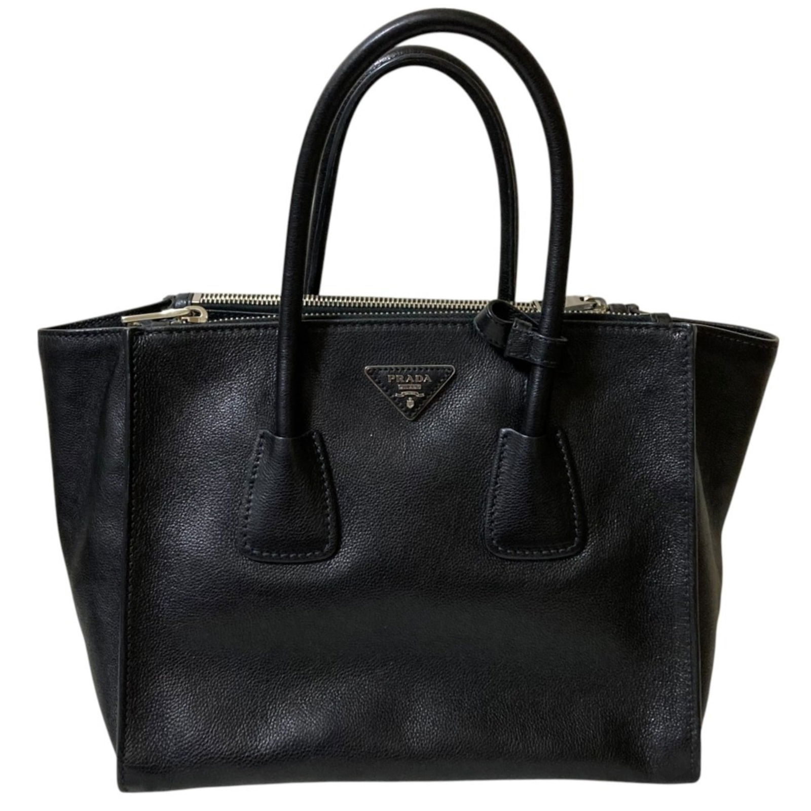 Black Leather Prada Twin Pocket Handbag from Italy: Black Leather Prada Twin Pocket Handbag from Italy This Prada Twin Pocket handbag is crafted from black leather and designed for women. The bag features a spacious interior with a twin pocket layout.