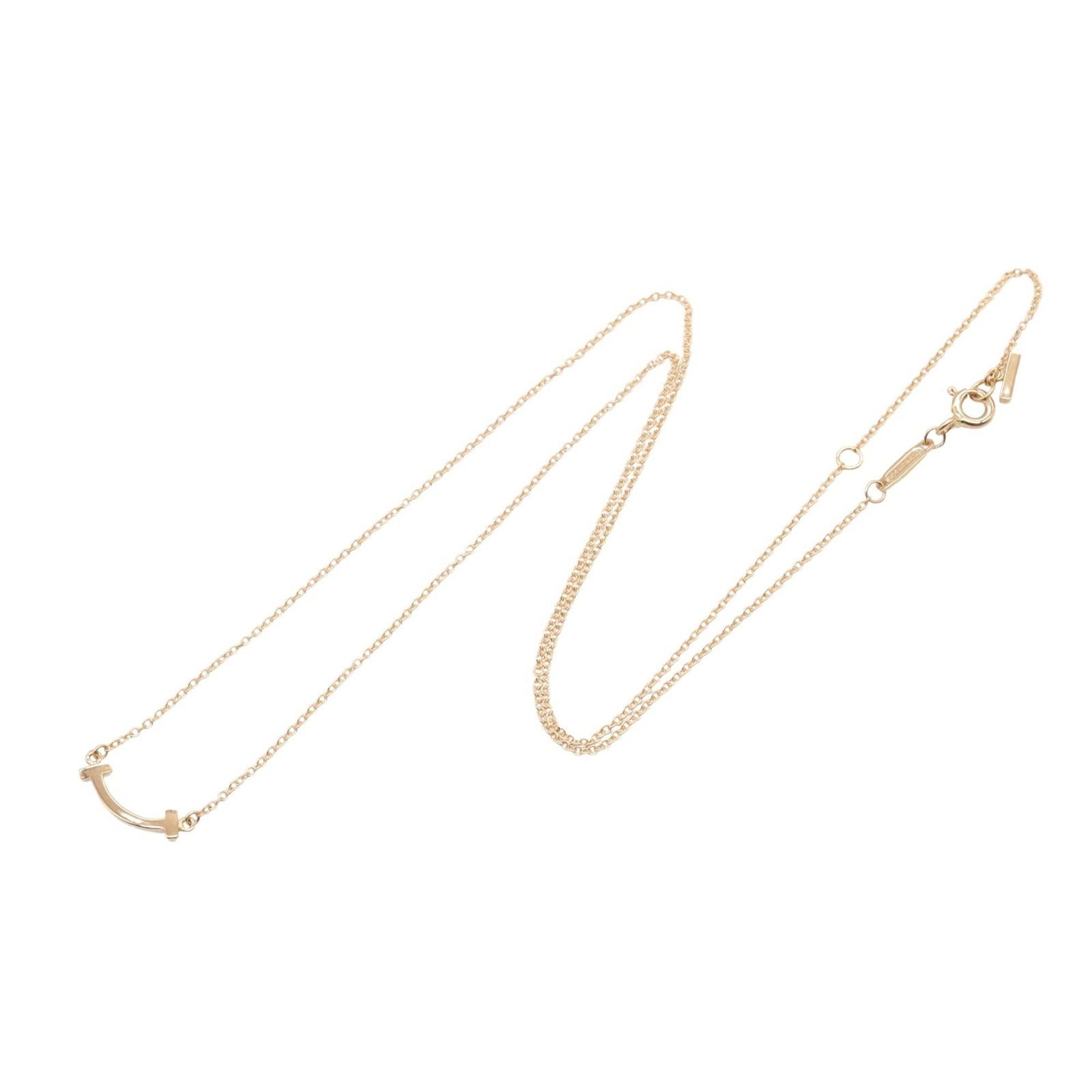 Rose Gold Tiffany T Smile Necklace for Women: Rose Gold Tiffany T Smile Necklace for Women This Tiffany & Co. T Smile necklace is crafted from rose gold and designed for women. It features a gold-toned finish with slight scratches and has been po