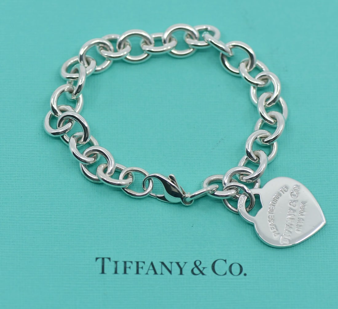 Return to Tiffany sterling silver charm bracelet with pouch: Return to Tiffany sterling silver charm bracelet with pouch This is a Tiffany & Co. Return to Tiffany charm bracelet crafted from 925 sterling silver. The bracelet features a classic charm design and