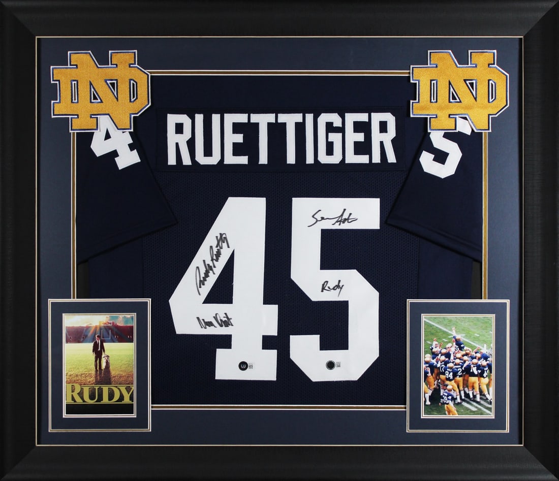Framed Notre Dame Jersey Signed by Rudy Ruettiger and Sean Astin Beckett Authenticated: Framed Notre Dame Jersey Signed by Rudy Ruettiger and Sean Astin Beckett Authenticated This is a professionally framed navy pro style jersey, personally signed by Rudy Ruettiger and Sean Astin of the
