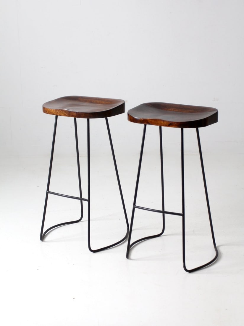 Vintage Hairpin Leg Stools Pair for Bar Kitchen: Vintage Hairpin Leg Stools Pair for Bar Kitchen This pair of vintage hairpin leg stools features dynamic metal legs with a curving design, complemented by wood saddle seats, making them an ideal choic