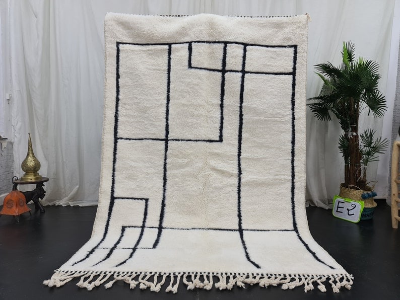 Authentic Handmade Moroccan Berber Wool Rug 8 x 5 Feet: Authentic Handmade Moroccan Berber Wool Rug 8 x 5 Feet This elegant soft white rug is an authentic handmade Moroccan Berber wool creation, featuring a striking black pattern. Crafted by skilled local