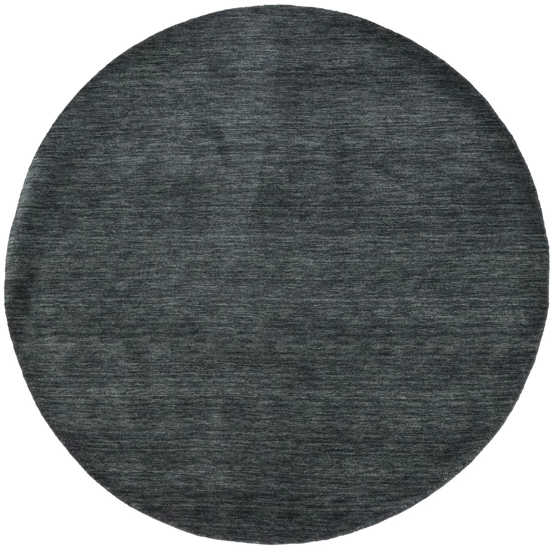 6' Round Hand-Loomed Wool Rug in Charcoal Modern Solid Design: 6' Round Hand-Loomed Wool Rug in Charcoal Modern Solid Design This solid charcoal round rug is hand-loomed from wool, providing a modern and versatile addition to your home decor. Crafted in India, th