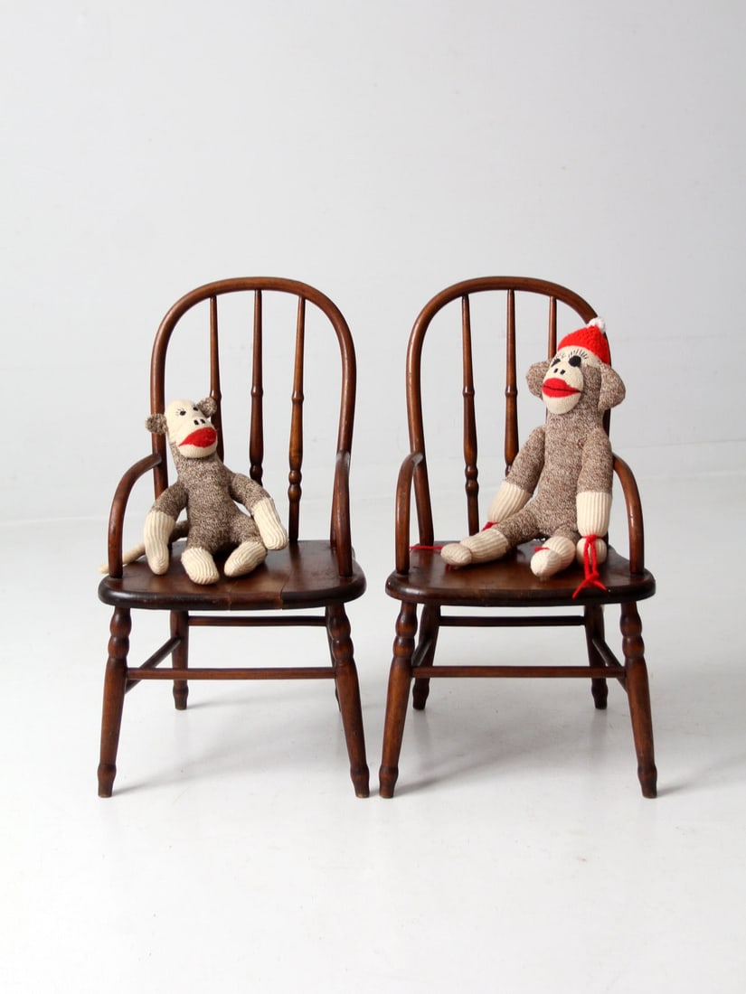 Antique Pair of Vintage Children's Wood Arm Chairs: Antique Pair of Vintage Children's Wood Arm Chairs This charming pair of vintage children's arm chairs showcases a delightful antique design, featuring classic turned spindle backs and legs. Crafted f