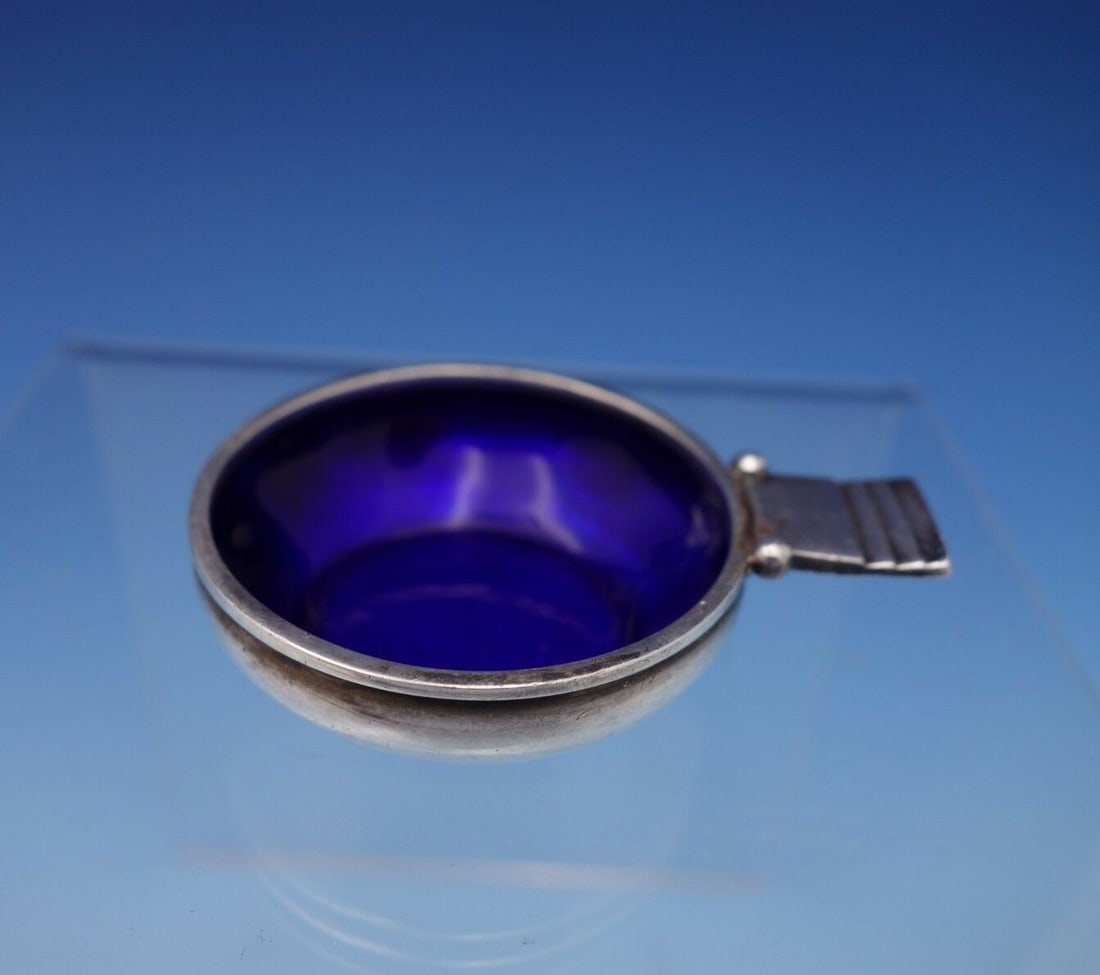 Georg Jensen Parallel Sterling Silver Salt Dip Cobalt Blue Enamel: Georg Jensen Parallel Sterling Silver Salt Dip Cobalt Blue Enamel This exquisite salt dip from Georg Jensen features a sleek design in sterling silver with a striking cobalt blue enamel accent. Crafte