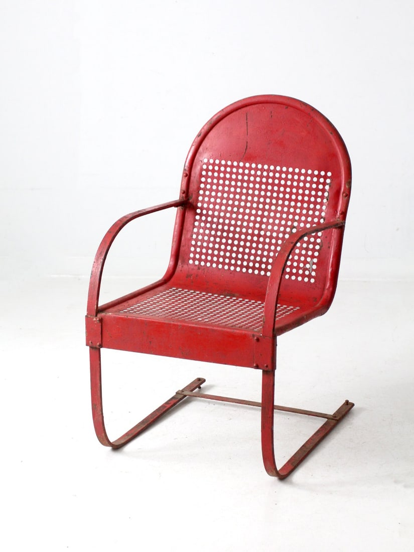 Retro Mid Century Red Metal Patio Chair with Perforated Design: Retro Mid Century Red Metal Patio Chair with Perforated Design This mid-century metal patio chair showcases an iconic perforated design, enhanced by a robust cantilever base. The weathered red finish