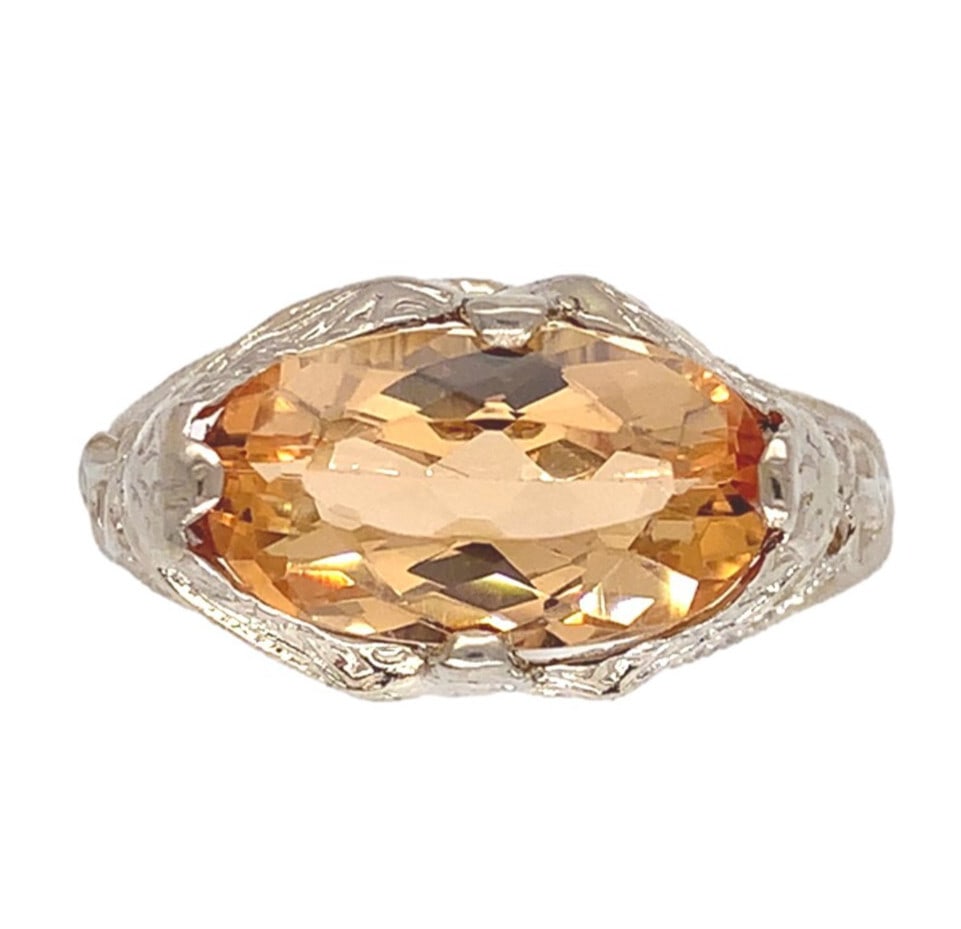 14k White Gold Vintage Filigree 2 Carat Peachy Topaz Ring GIA Certified: 14k White Gold Vintage Filigree 2 Carat Peachy Topaz Ring GIA Certified This exquisite vintage ring features a stunning 2.00-carat oval precious topaz that radiates a captivating peachy-golden hue. Cr
