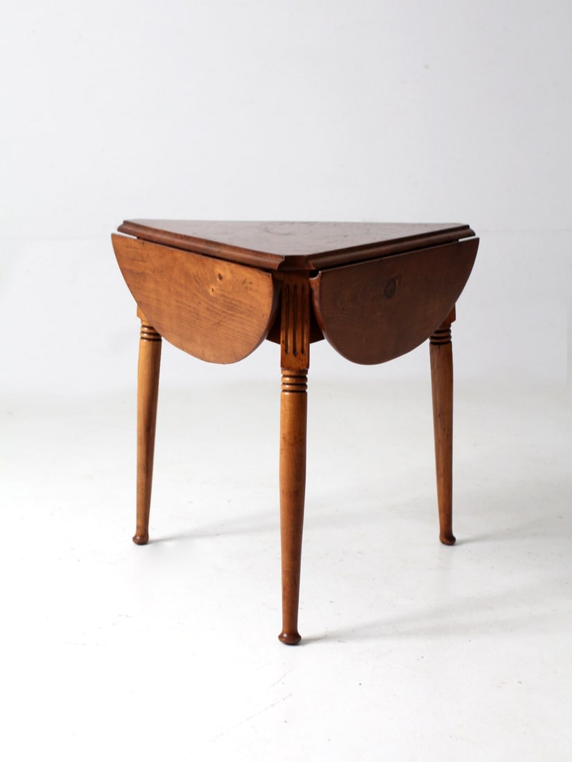 Vintage Mid Century Triangular Drop Leaf End Table: Vintage Mid Century Triangular Drop Leaf End Table This mid-century wooden drop leaf end table showcases a unique triangular design that expands to reveal a rounded tabletop. It's a versatile piece, p