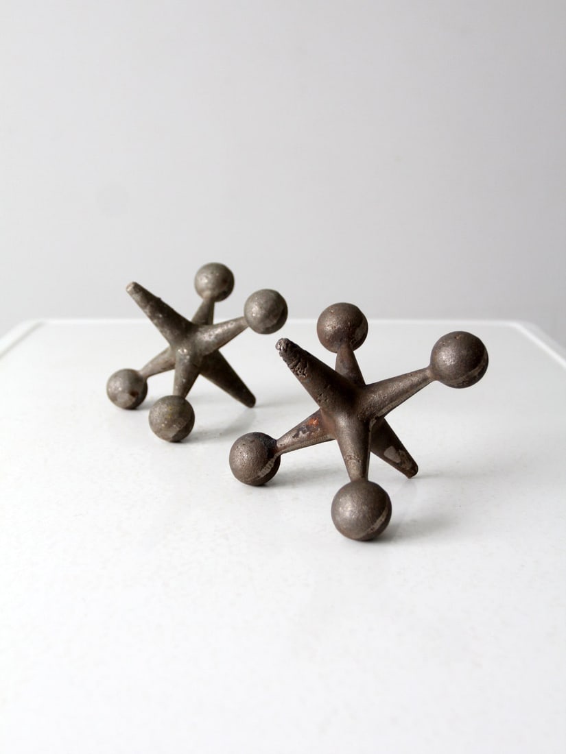 Mid-Century Cast Iron Jacks Decorative Pair for Home or Office: Mid-Century Cast Iron Jacks Decorative Pair for Home or Office Enhance your workspace or home decor with this striking pair of Mid-Century cast iron jack sculptures. Perfect as decorative accents, the