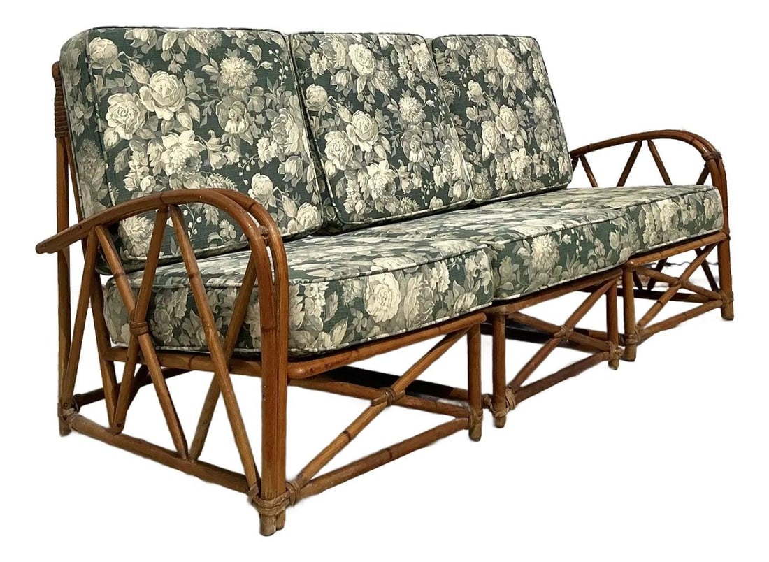 Vintage Heywood Wakefield Coastal Bent Rattan Sofa with Floral Cushions: Vintage Heywood Wakefield Coastal Bent Rattan Sofa with Floral Cushions Elevate your decor with this stunning vintage bent rattan sofa, attributed to Heywood-Wakefield. This mid-century piece features