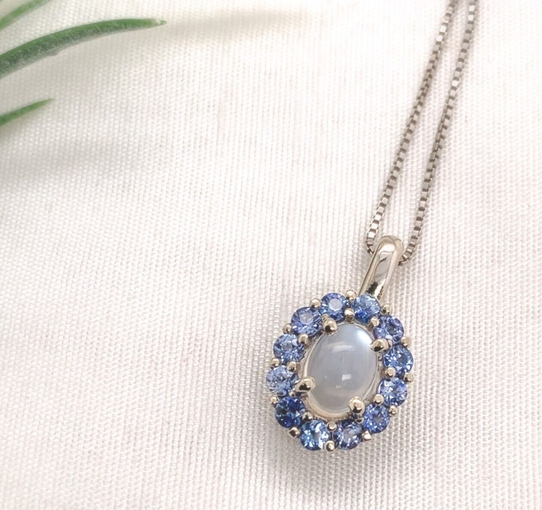 14k White Gold Moonstone Sapphire Pendant with 20" Chain: 14k White Gold Moonstone Sapphire Pendant with 20" Chain This exquisite pendant features a stunning 1.25 carat genuine natural moonstone set in luxurious 14k white gold. The oval cabochon cut moonston