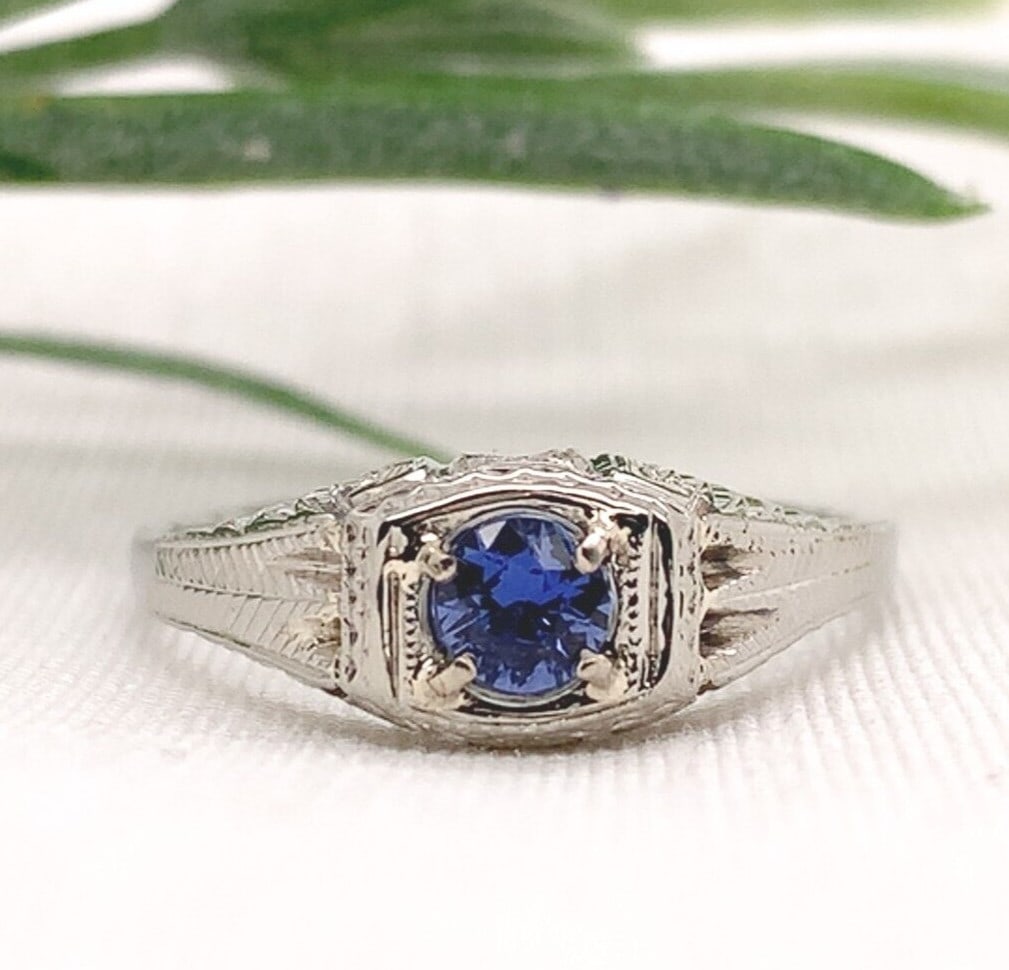Art Deco 18k White Gold .28ct Blue Sapphire Engraved Ring J7171: Art Deco 18k White Gold .28ct Blue Sapphire Engraved Ring J7171 Discover the elegance of this 18k White Gold Art Deco Ring, featuring a stunning .28ct genuine natural blue sapphire. The ring showcases