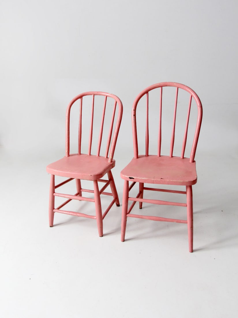 Charming Pair of Antique Pink Spindle Back Chairs: Charming Pair of Antique Pink Spindle Back Chairs This charming pair of antique spindle back chairs showcases a delightful pink paint finish that adds a touch of whimsy to any space. Each chair featur