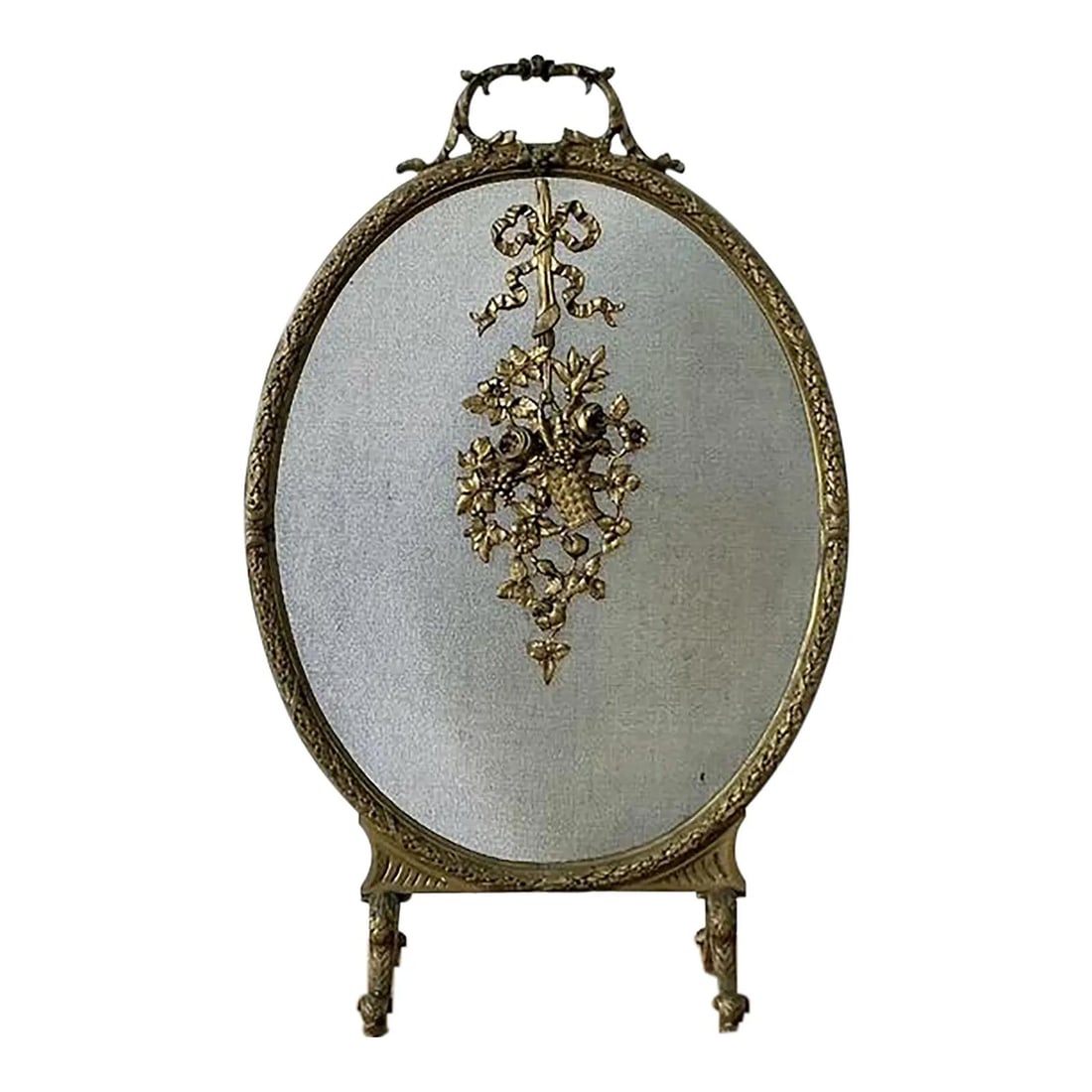 French Louis XVI Style Brass Oval Fireplace Screen with Ribbon and Floral Motif: French Louis XVI Style Brass Oval Fireplace Screen with Ribbon and Floral Motif This vintage French Louis XVI style fireplace screen features an elegant oval silhouette framed in ornate cast brass wit