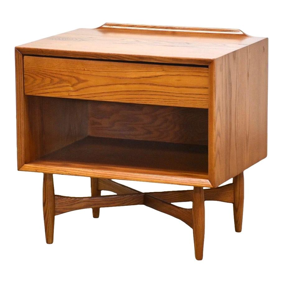 Heywood Wakefield Mid Century Modern Oak Nightstand: Heywood Wakefield Mid Century Modern Oak Nightstand This mid-century modern nightstand showcases the impeccable craftsmanship of Heywood Wakefield, featuring a lipped back and a striking cross stretch