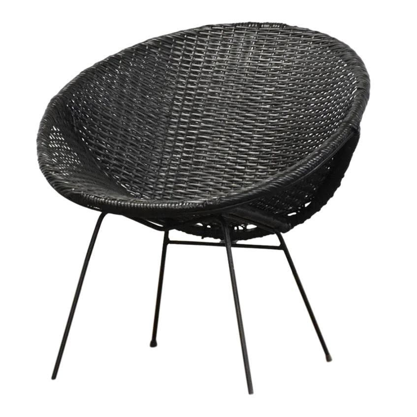 1970s Mid Century Modern Black Wicker Iron Lounge Chair: 1970s Mid Century Modern Black Wicker Iron Lounge Chair This striking lounge chair from the 1970s combines mid-century modern aesthetics with functionality. Featuring a black wicker cane seat and a st